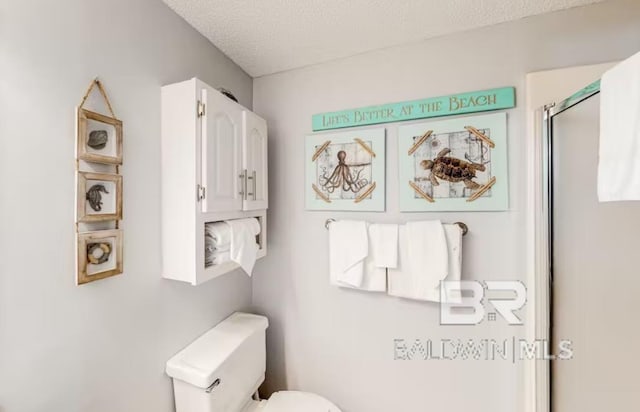 bathroom featuring toilet and a textured ceiling