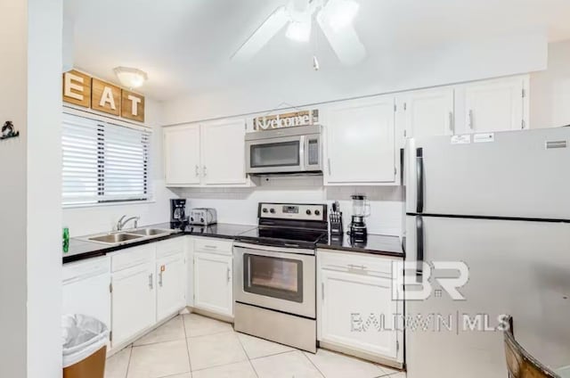 kitchen with ceiling fan, electric range oven, white cabinets, sink, and white refrigerator