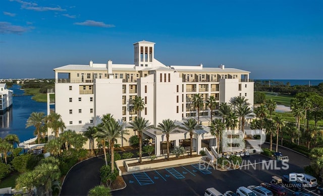 view of building exterior featuring a water view and uncovered parking