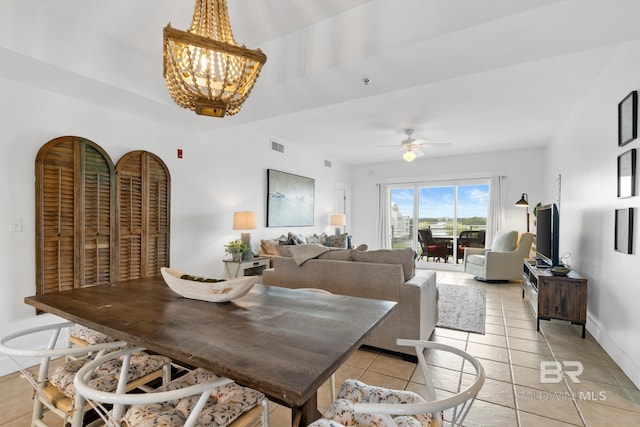 dining space with light tile patterned floors, ceiling fan with notable chandelier, baseboards, and visible vents