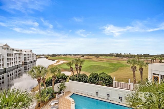 pool featuring golf course view, a water view, and fence
