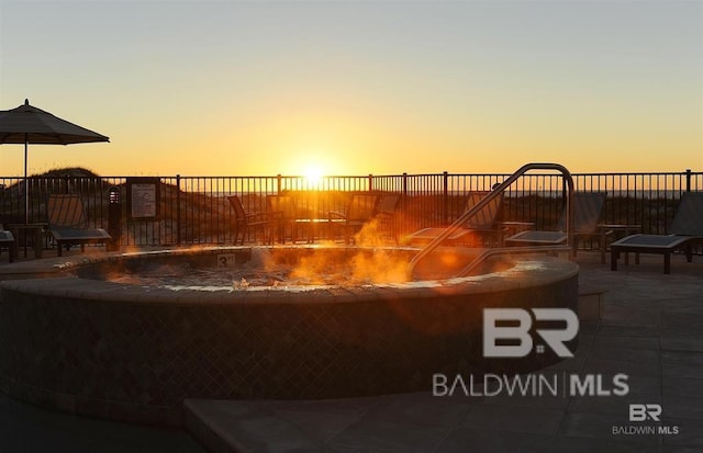 patio terrace at dusk featuring fence