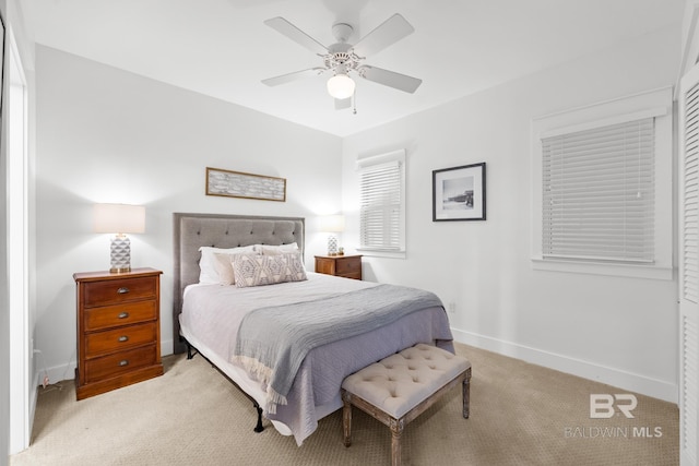 bedroom featuring light carpet, baseboards, and ceiling fan