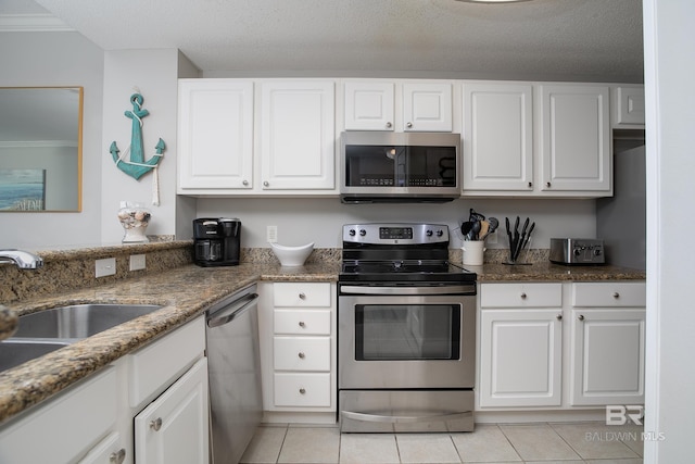 kitchen with white cabinets, a textured ceiling, and stainless steel appliances