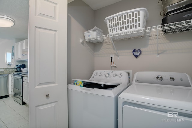 clothes washing area with light tile patterned floors and washing machine and clothes dryer