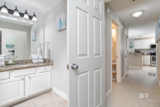 bathroom featuring tile patterned floors, vanity, and a textured ceiling