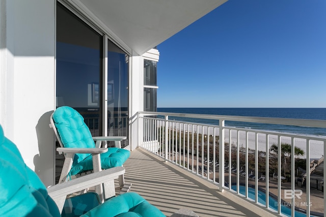 balcony with a water view and a beach view