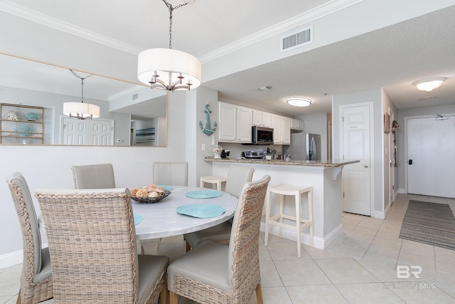 tiled dining room with crown molding, a textured ceiling, and an inviting chandelier