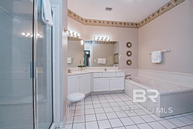 bathroom with a garden tub, double vanity, visible vents, a stall shower, and a sink