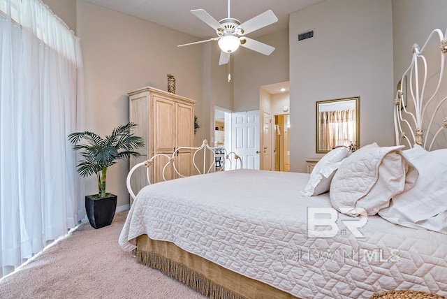 bedroom with visible vents, carpet flooring, vaulted ceiling, ceiling fan, and multiple windows