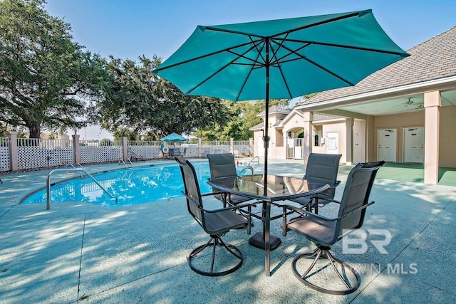 view of swimming pool with a fenced in pool, a patio, a ceiling fan, outdoor dining space, and fence