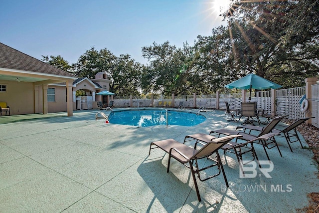 community pool featuring a patio area and fence