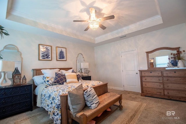 bedroom with crown molding, carpet flooring, ceiling fan, and a tray ceiling
