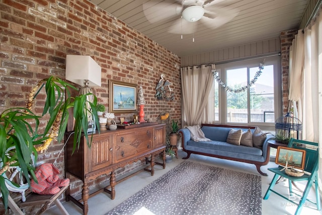 sitting room with ceiling fan and brick wall