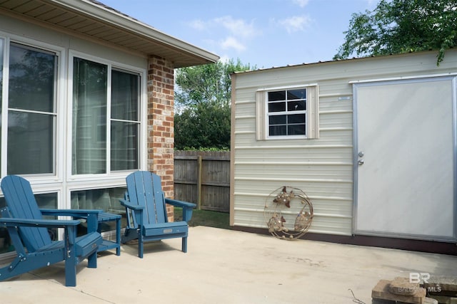 view of patio featuring fence and an outbuilding