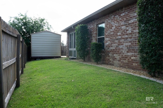 view of yard with an outbuilding, a shed, and fence
