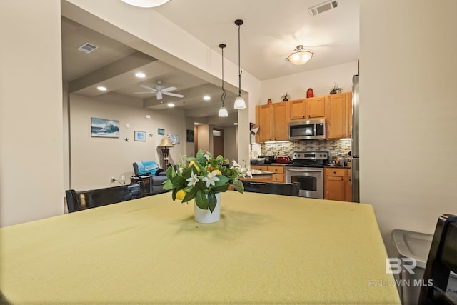 kitchen with appliances with stainless steel finishes, pendant lighting, decorative backsplash, beamed ceiling, and ceiling fan