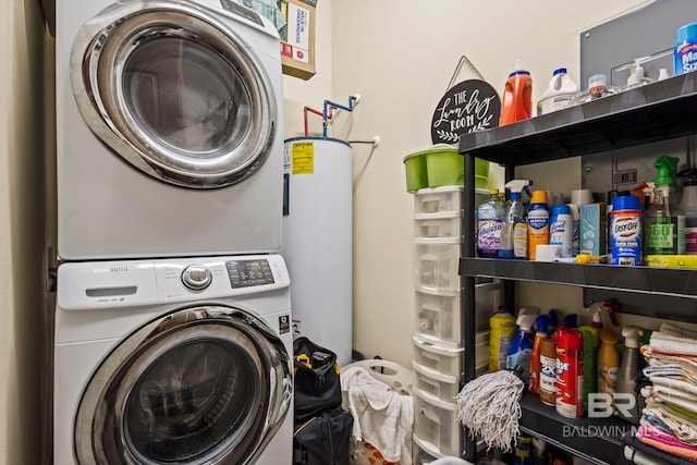 washroom featuring water heater and stacked washer / drying machine