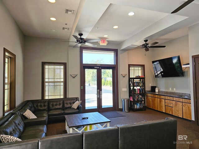 living room featuring french doors, ceiling fan, and dark carpet