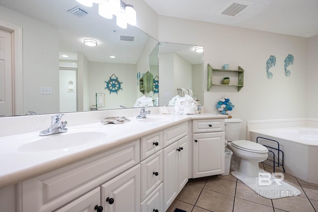 bathroom featuring vanity, a bath, tile patterned floors, and toilet