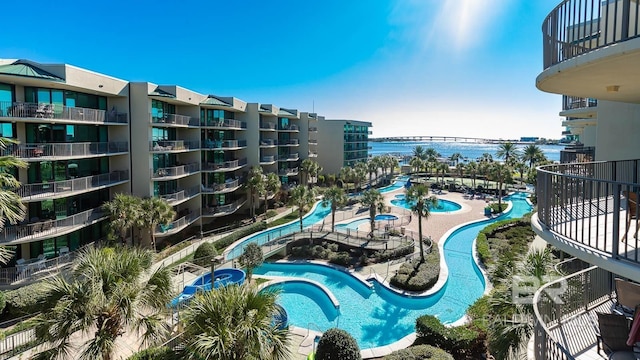 view of swimming pool featuring a hot tub and a water view