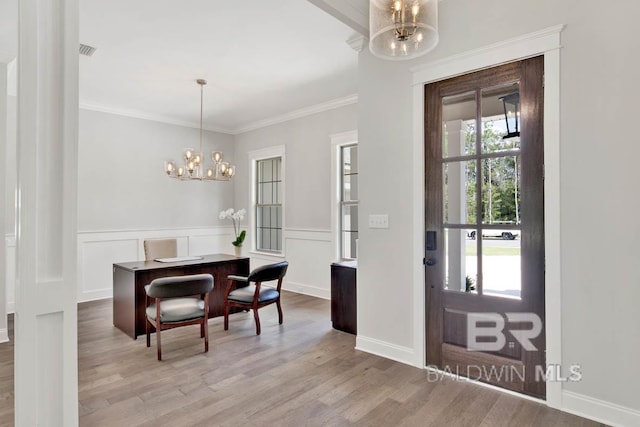 dining space with an inviting chandelier, crown molding, and light hardwood / wood-style floors