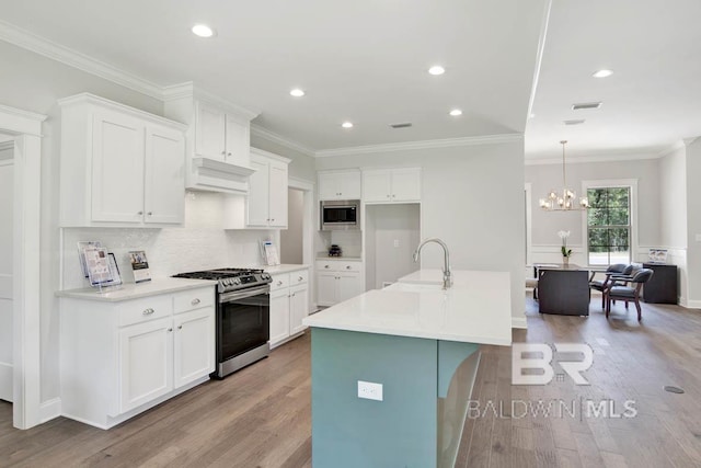 kitchen with white cabinetry, light hardwood / wood-style floors, appliances with stainless steel finishes, a kitchen island with sink, and sink