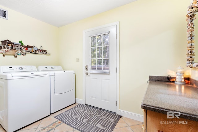 laundry area with washer and dryer and light tile patterned flooring