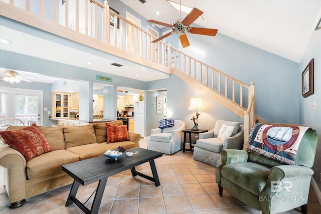 living room featuring light tile patterned floors, high vaulted ceiling, and ceiling fan