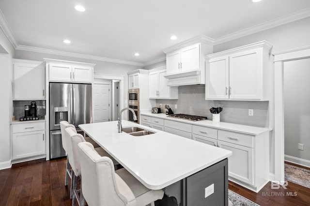 kitchen featuring sink, appliances with stainless steel finishes, an island with sink, white cabinets, and dark hardwood / wood-style flooring