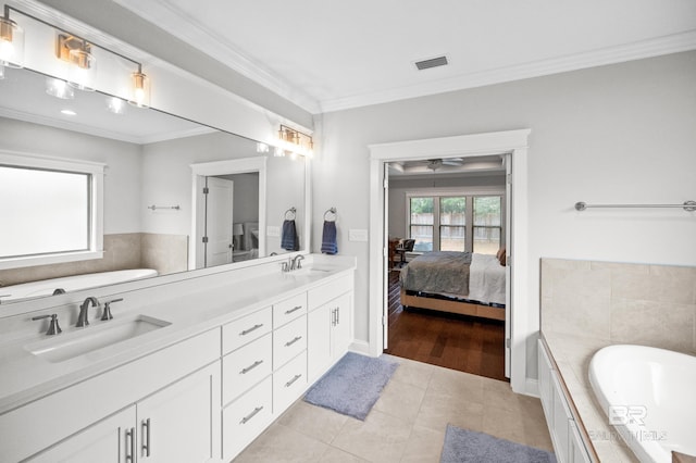 bathroom featuring a relaxing tiled tub, vanity, tile patterned flooring, and ornamental molding