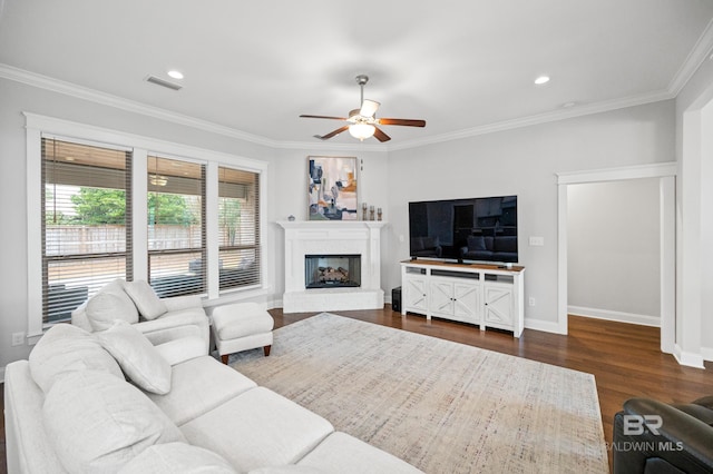 living room with crown molding, dark wood-type flooring, and ceiling fan