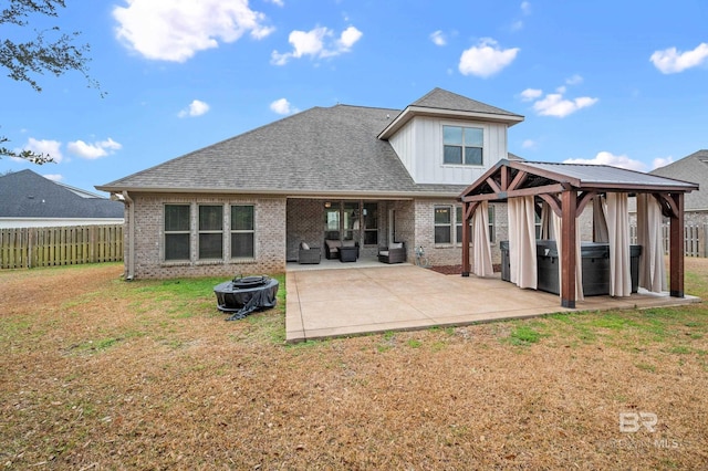 rear view of property with a gazebo, a yard, and a patio area