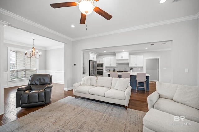 living room featuring ornamental molding, dark hardwood / wood-style floors, and ceiling fan with notable chandelier