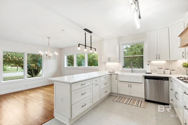 kitchen with a sink, backsplash, a peninsula, and appliances with stainless steel finishes