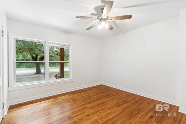 spare room with baseboards, light wood-style floors, and ceiling fan