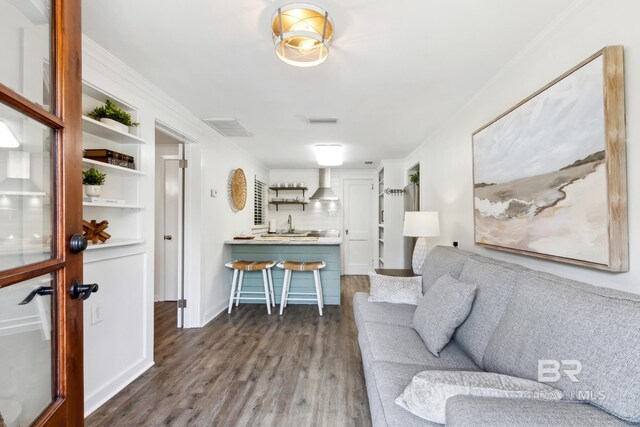 living room featuring crown molding and dark wood-type flooring