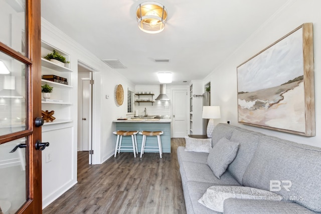 living room featuring dark wood-style floors, visible vents, and crown molding