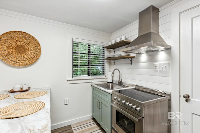 kitchen with green cabinetry, a sink, stainless steel range with electric stovetop, island range hood, and ornamental molding