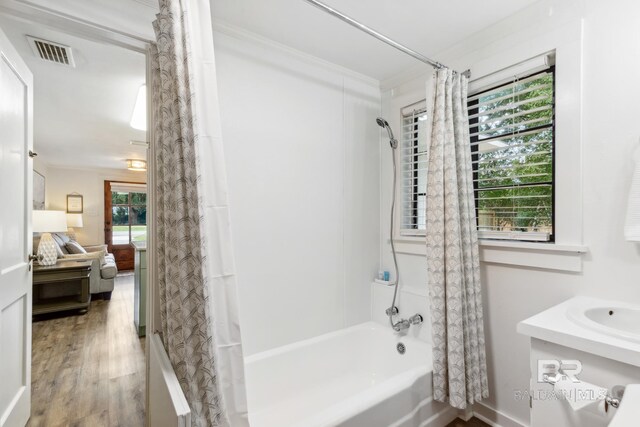 bathroom featuring shower / bathtub combination with curtain, a wealth of natural light, hardwood / wood-style floors, and vanity