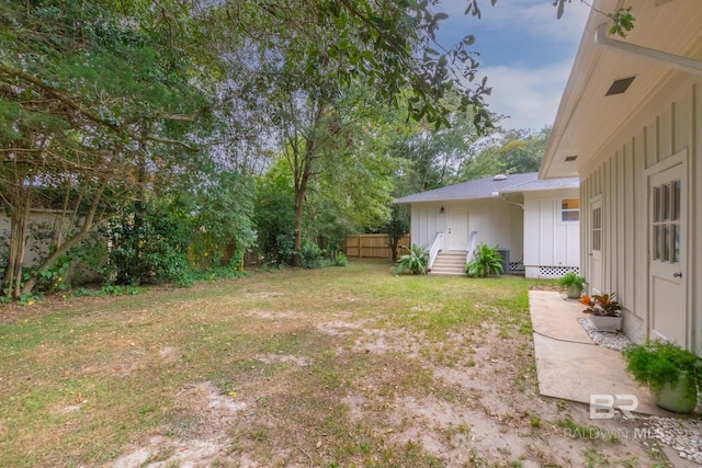 view of yard featuring fence and entry steps