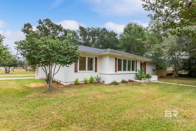 ranch-style home featuring board and batten siding and a front yard
