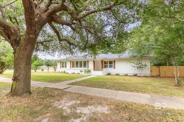 ranch-style home with a front lawn and fence