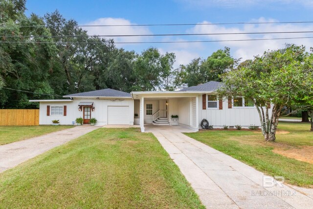 single story home featuring a front lawn, a carport, and a garage