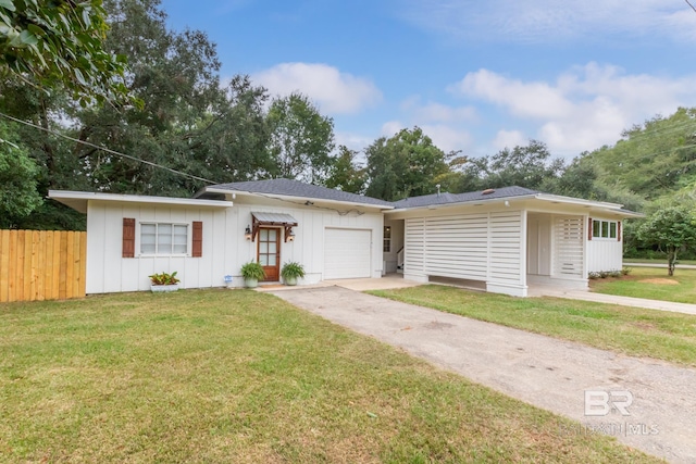 single story home featuring concrete driveway, fence, an attached garage, board and batten siding, and a front lawn