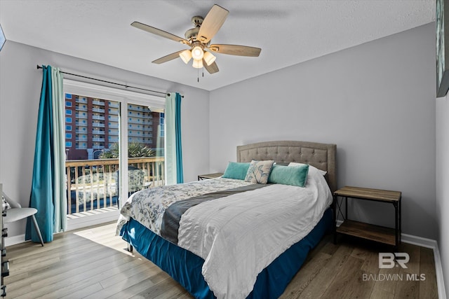 bedroom featuring hardwood / wood-style flooring, a textured ceiling, access to exterior, and ceiling fan