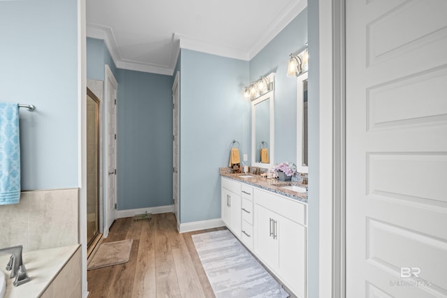 bathroom with hardwood / wood-style floors, vanity, a shower with door, and crown molding