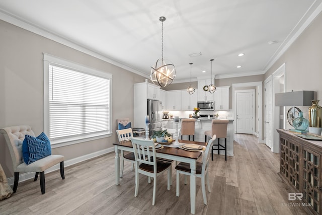 dining room with light wood-type flooring, an inviting chandelier, and ornamental molding