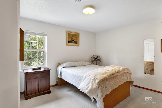 bedroom featuring baseboards and light colored carpet