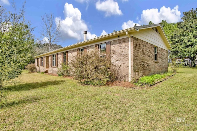 view of side of home with a lawn and brick siding